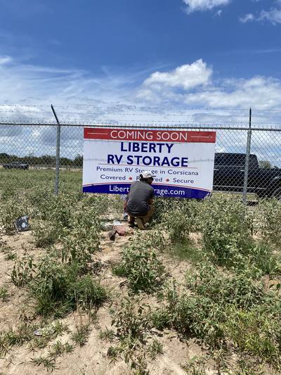 Liberty RV Storage "Coming Soon" banner being hung on the site fence